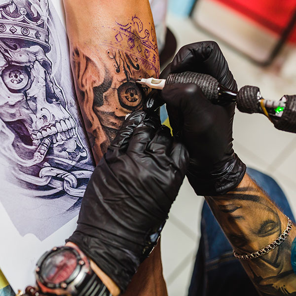 licensed artist working on skull tattoo art