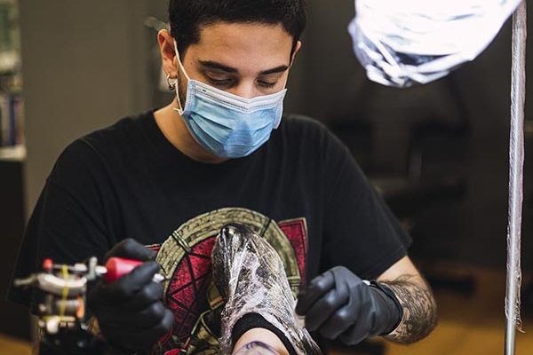 apprentice holding a tattoo machine