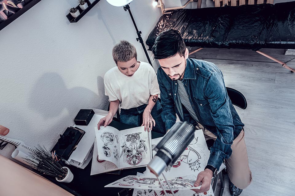 tattoo artist looking at a tattoo apprentice portfolio