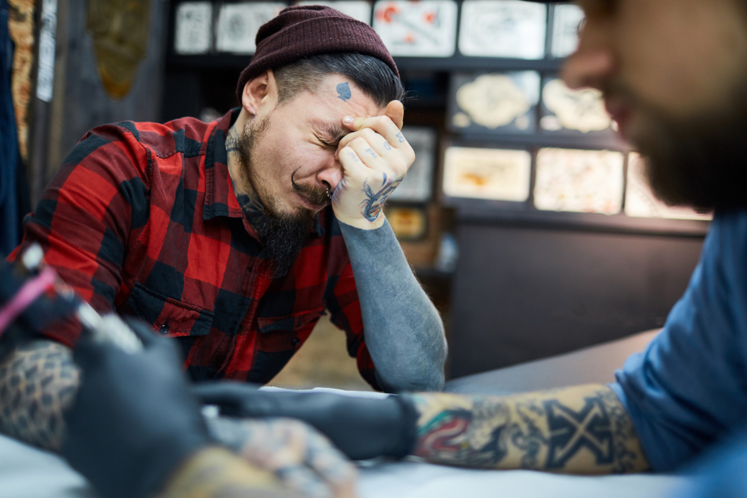 tattoo artist giving a client a new tattoo