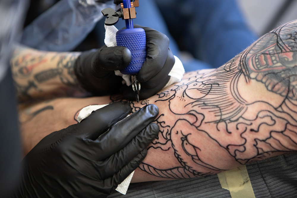 person getting a tattoo on their arm