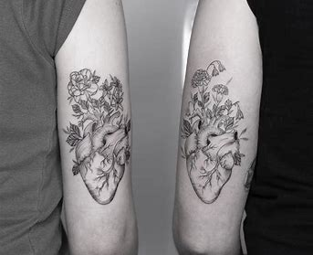 Fine line tattoo of flowers growing from an anatomical hearty