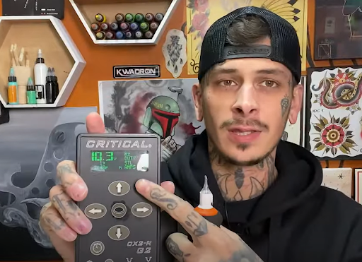 professional tattoo artist holding a tattoo power supply