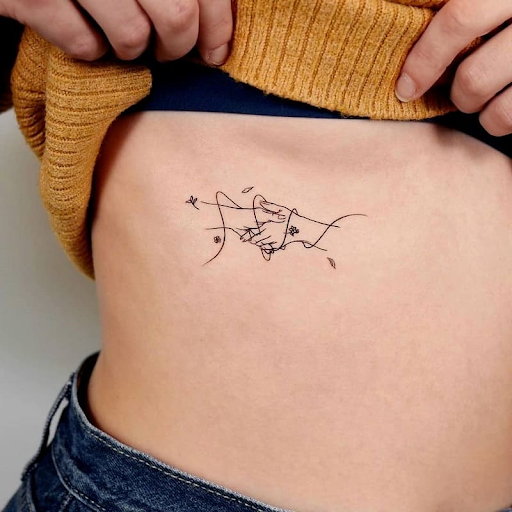 Fine line tattoo of hands shaking each other 